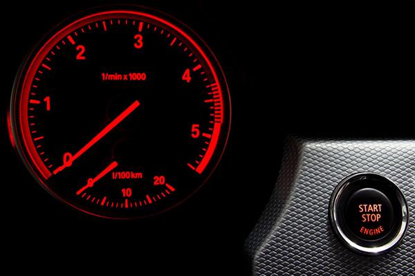 red rev counter on car with start stop engine button on car dash